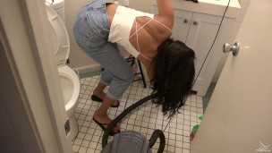 bombshell desi girl vacuuming the bathroom in crop top and jeans